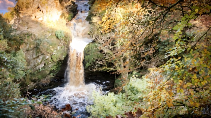 The Ness Waterfall dropping through the wooded gorge in autumn colour