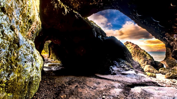 Looking out to sea through the red rock arches of the Cushendun Caves