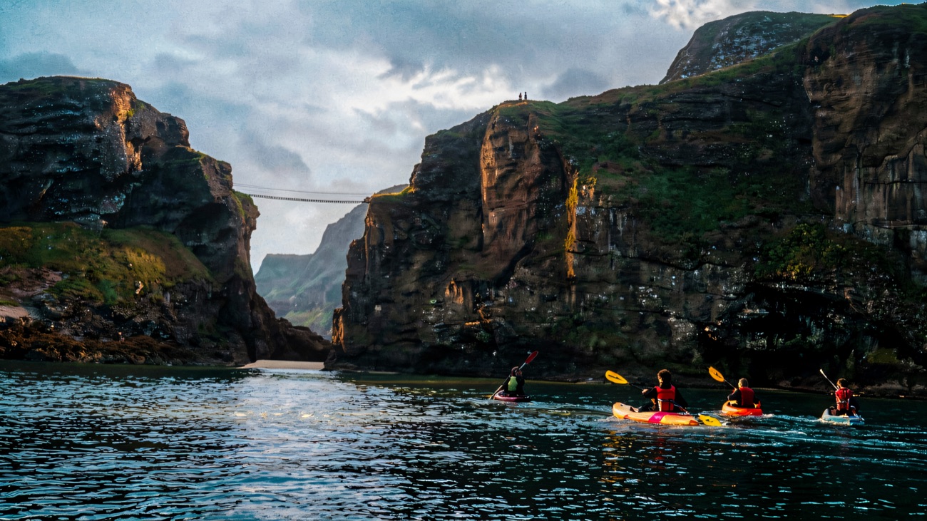 Paddling out beneath the towering cliffs and rope bridge