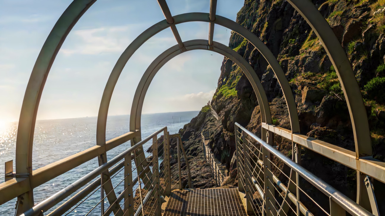 Looking through the steel arches of a walkway bolted to the sea cliff on the Gobbins path