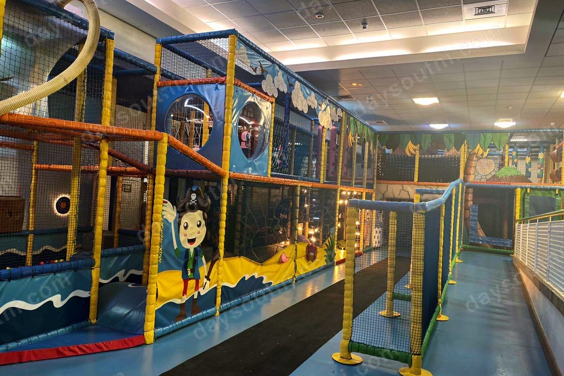 The pirate-themed two-storey soft play frame at Adventure World, Bangor, with a ship mural and yellow-and-blue climbing frame