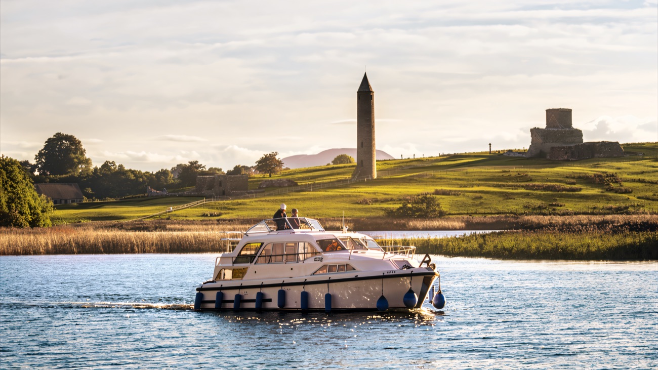 A cruiser passing the round tower and monastic ruins on Devenish Island.