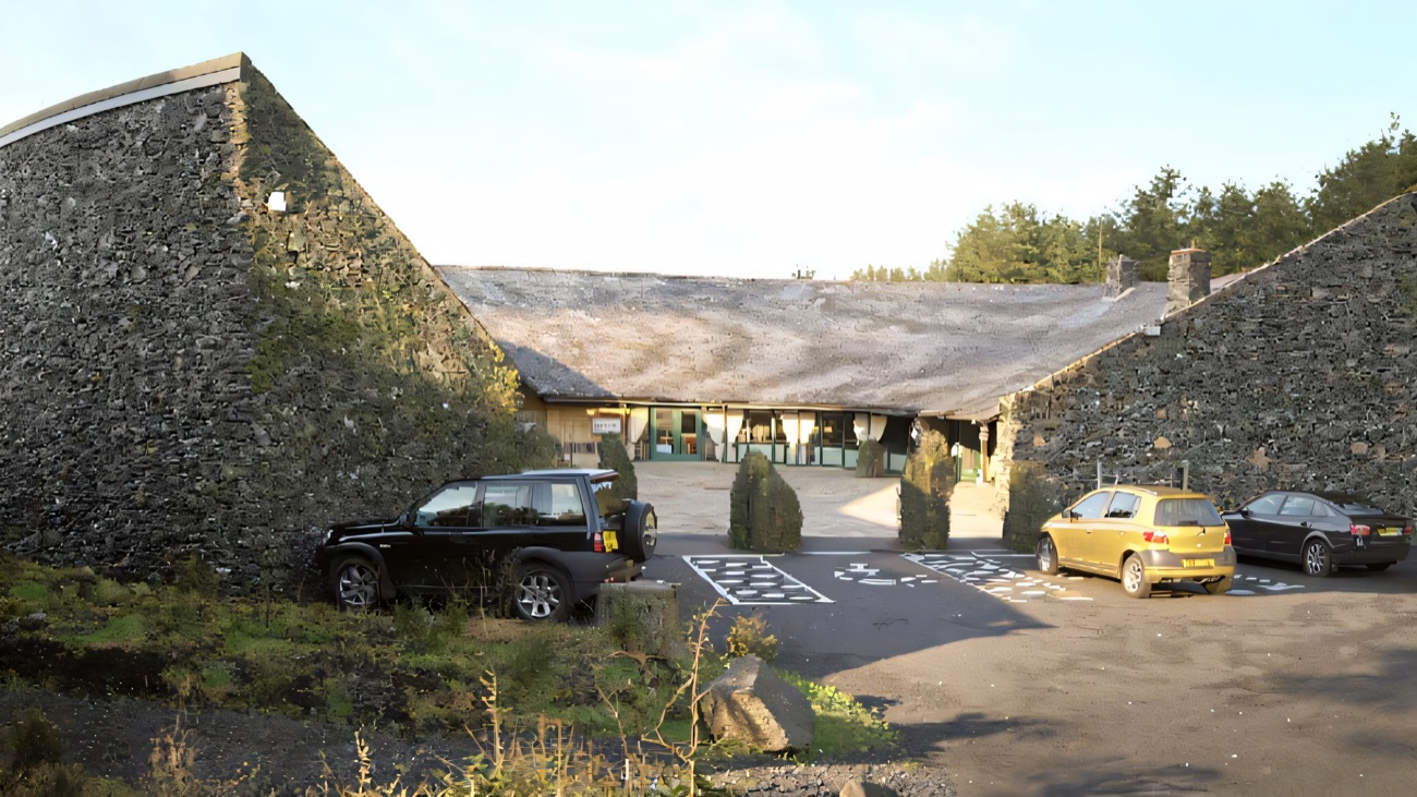 The centre's distinctive curved drystone-and-thatch building, wrapped into the Tyrone bog landscape.