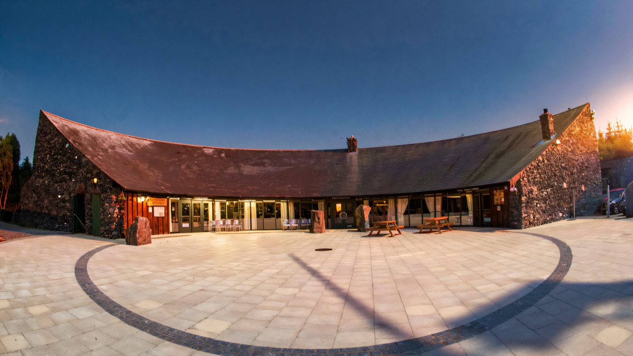 The wide sweep of the courtyard and standing stones under summer blue sky.