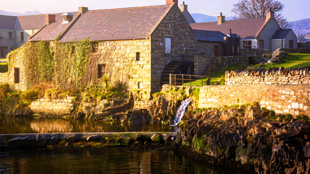 The cornmill glowing across the water in warm light