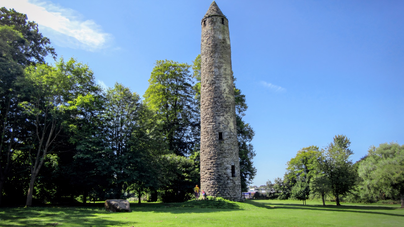 The tenth-century round tower standing tall over the parkland on a bright summer day