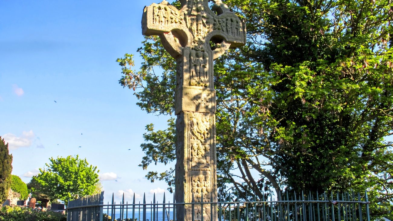 The great sandstone high cross standing tall against the sky, its carved panels believed to date from the 10th century.
