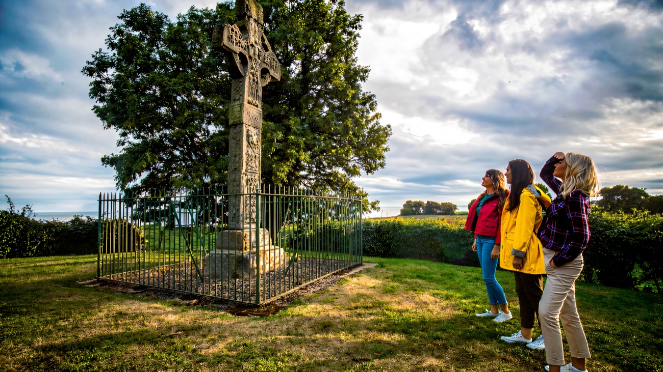 Visitors take in the cross on its quiet green hilltop above the shore of Lough Neagh.