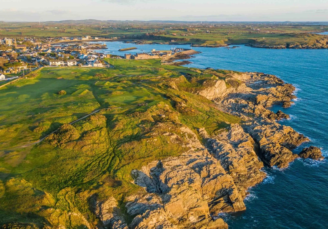 Golden evening light on the rocky Lecale coast at Ardglass with the village and golf links beyond