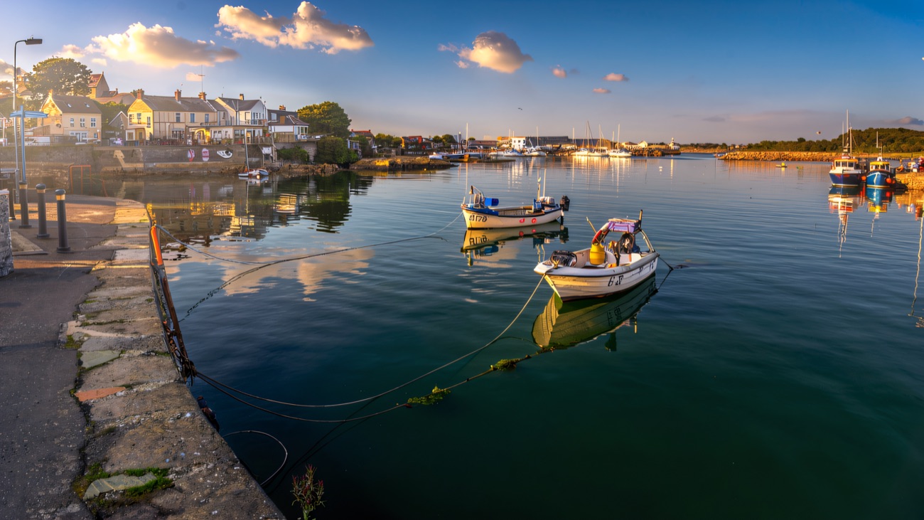 Small boats moored off the quay, the village lining the harbour