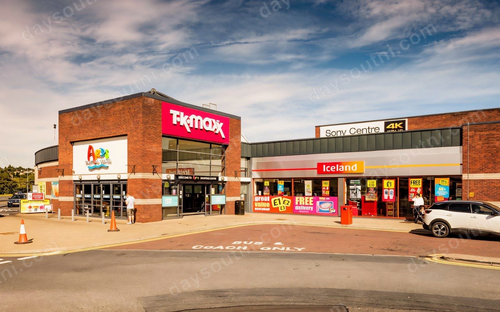 The front of Ards Shopping Centre in Newtownards, with the TK Maxx entrance tower and the Iceland shopfront under a blue sky