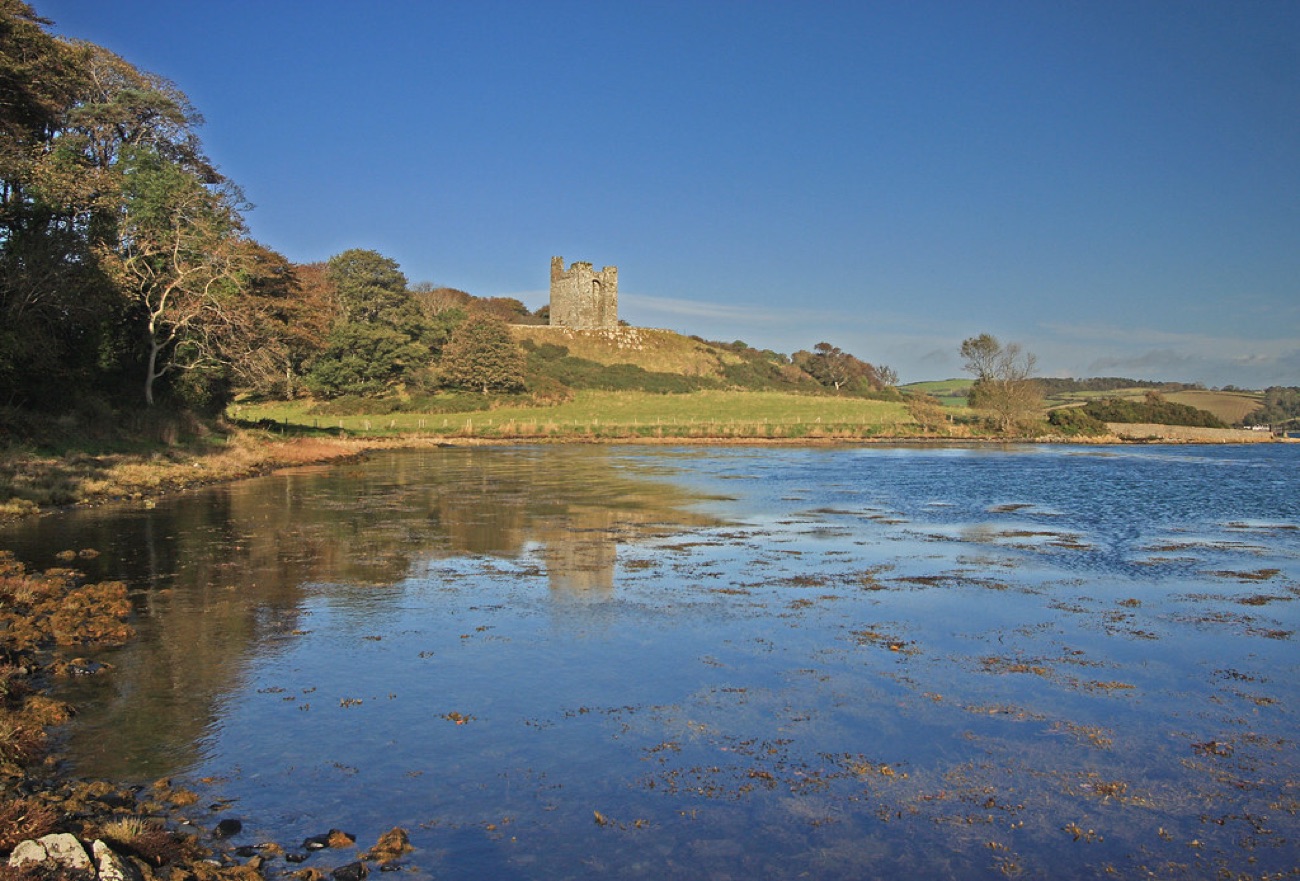 The tower house on its hill reflected in the calm waters of Strangford Lough