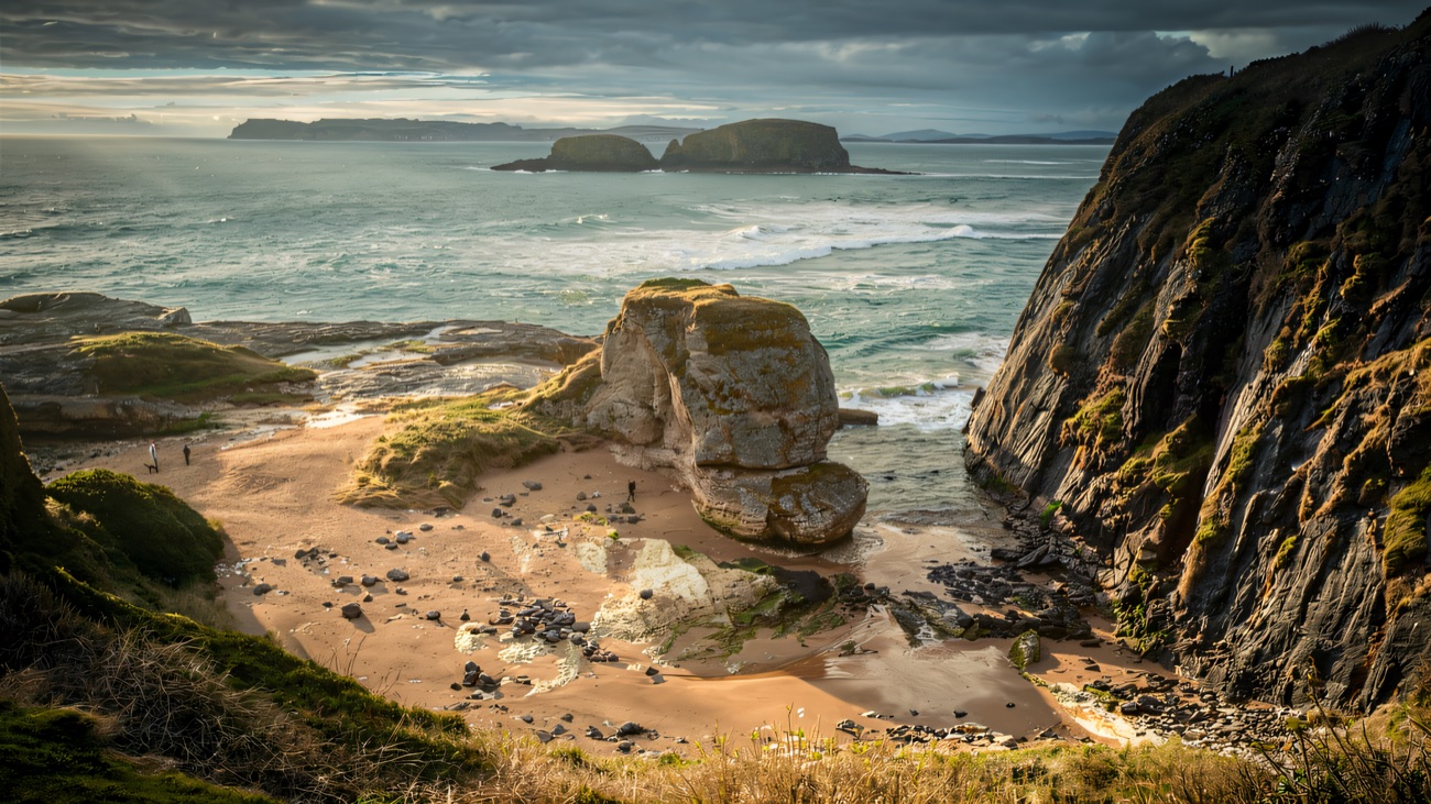 Sandy cove below the cliffs with Sheep Island out on the horizon