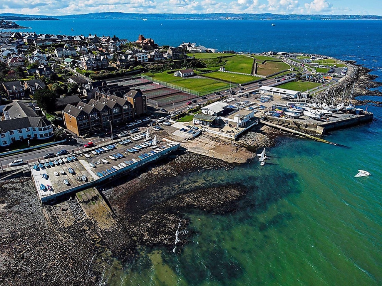 Aerial view of Ballyholme Yacht Club and slipway with dinghies and the seafront green at the eastern end of the bay in Bangor