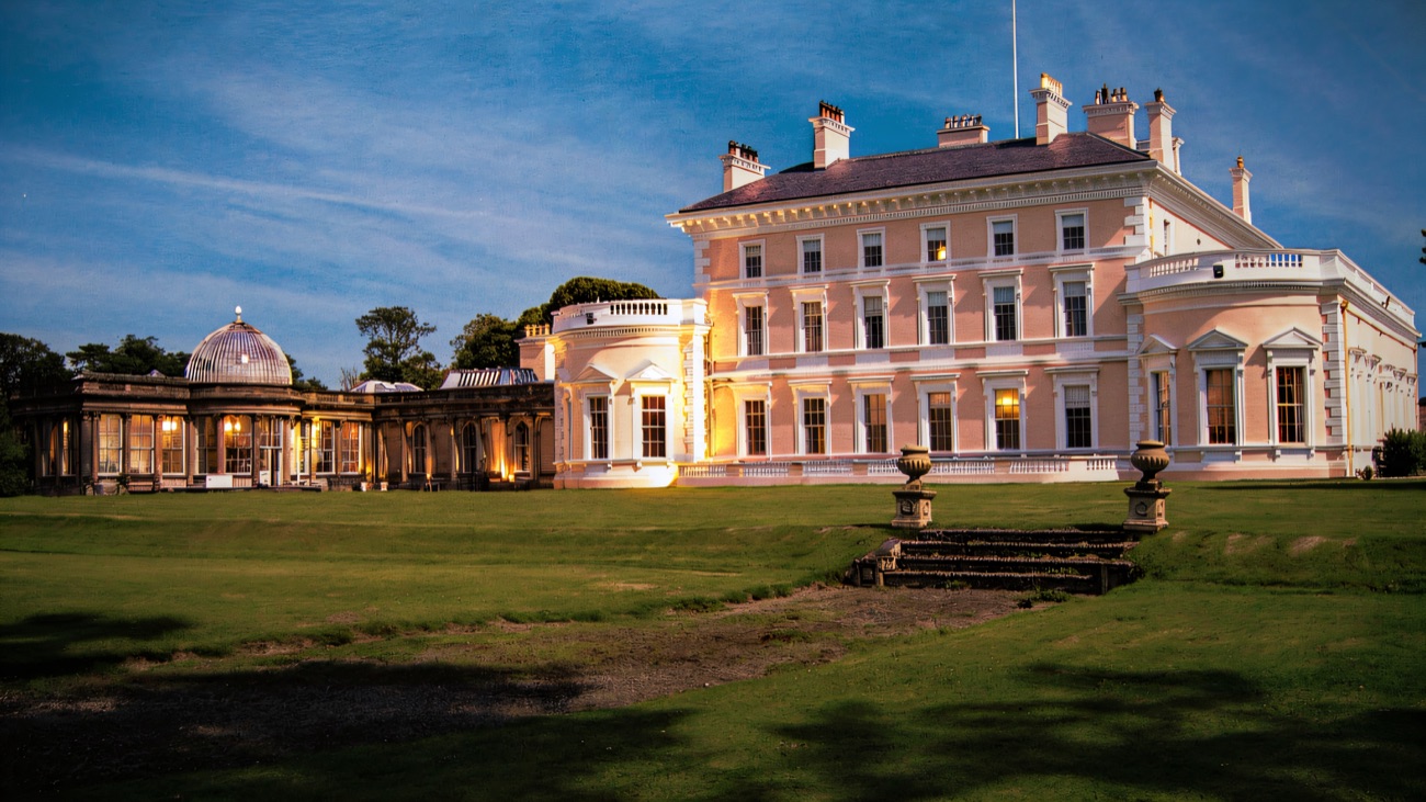 Ballywalter Park mansion seen from the side with its long domed conservatory wing to the left and stone garden urns