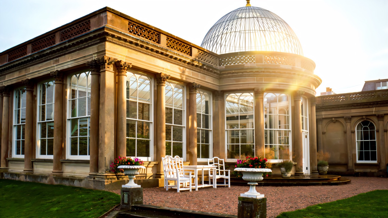 The domed sandstone conservatory at Ballywalter Park, ringed by columns with garden urns and steps in front