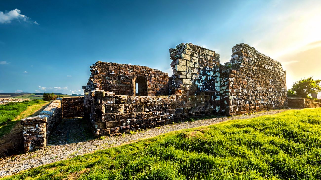 The roofless nave and gable of the old church standing bright against blue sky