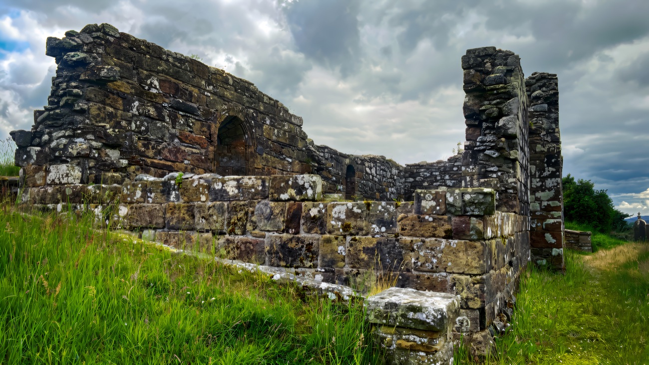 Moody light along the weathered side wall and its high window