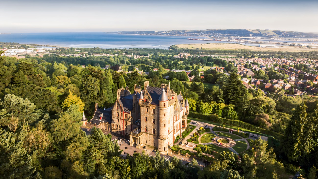 Belfast Castle from above with the full sweep of Belfast Lough beyond it