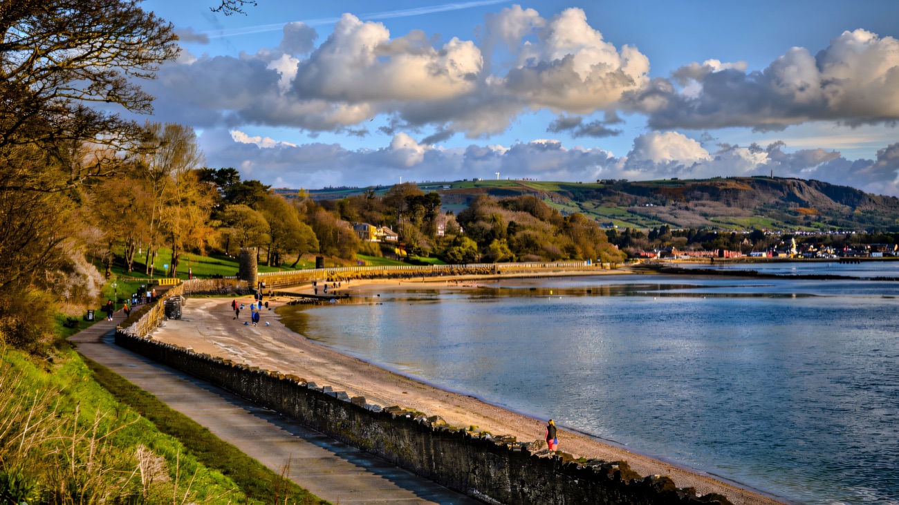 The seawall promenade sweeping around the bay towards the hills