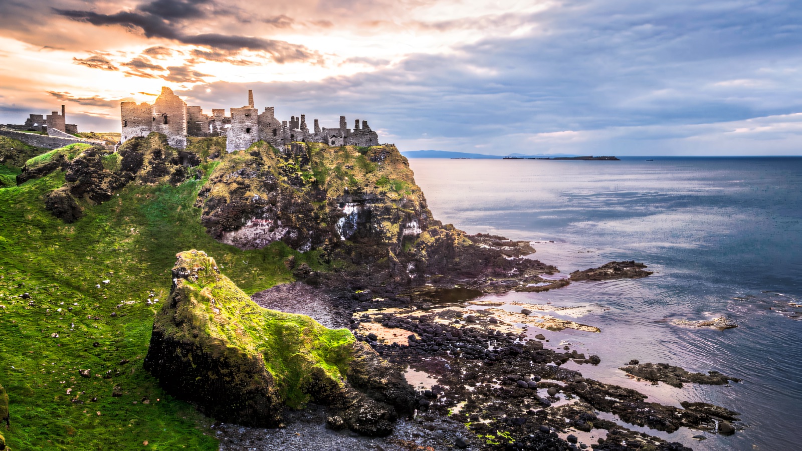 Dunluce Castle ruins on the clifftop above the sea