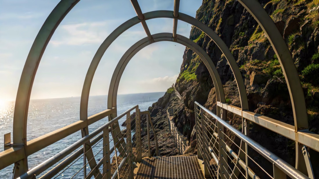 Looking through the steel arches of a Gobbins walkway bolted to the sea cliff