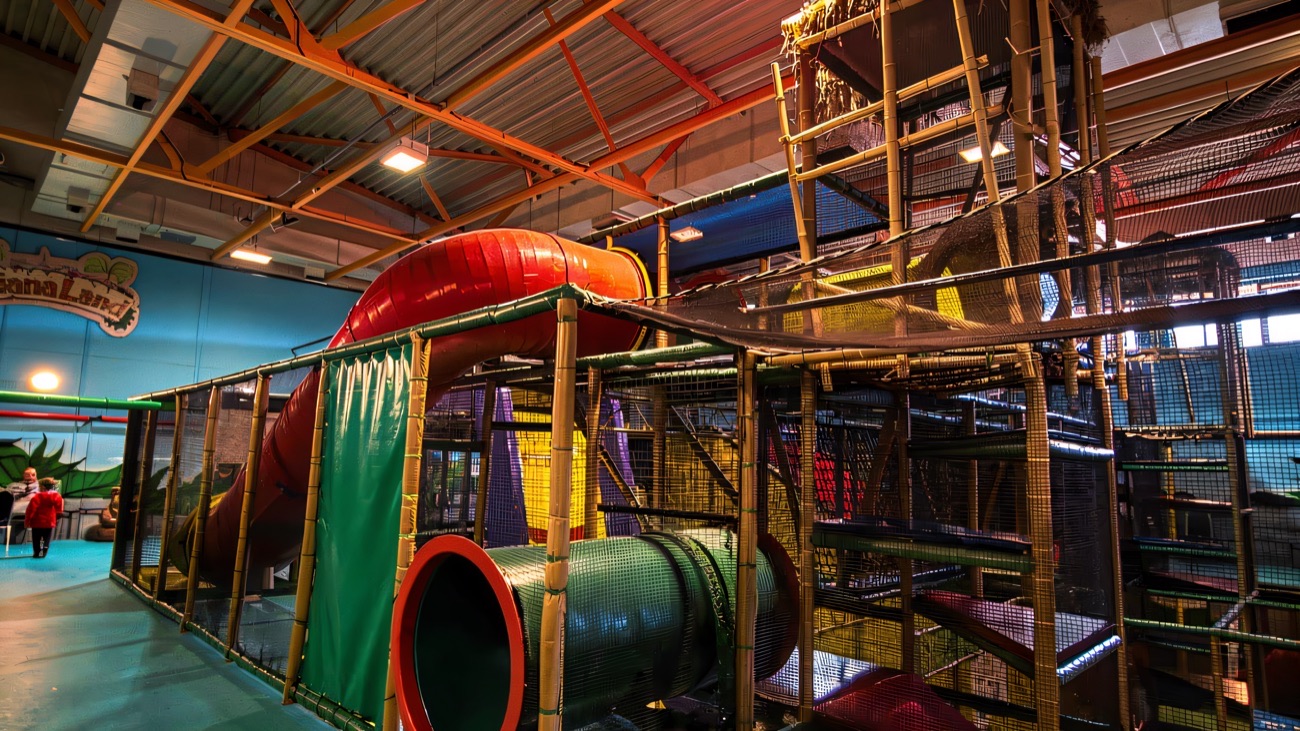The jungle-themed multi-level play frame and red tube slide at Indiana Land, Dundonald