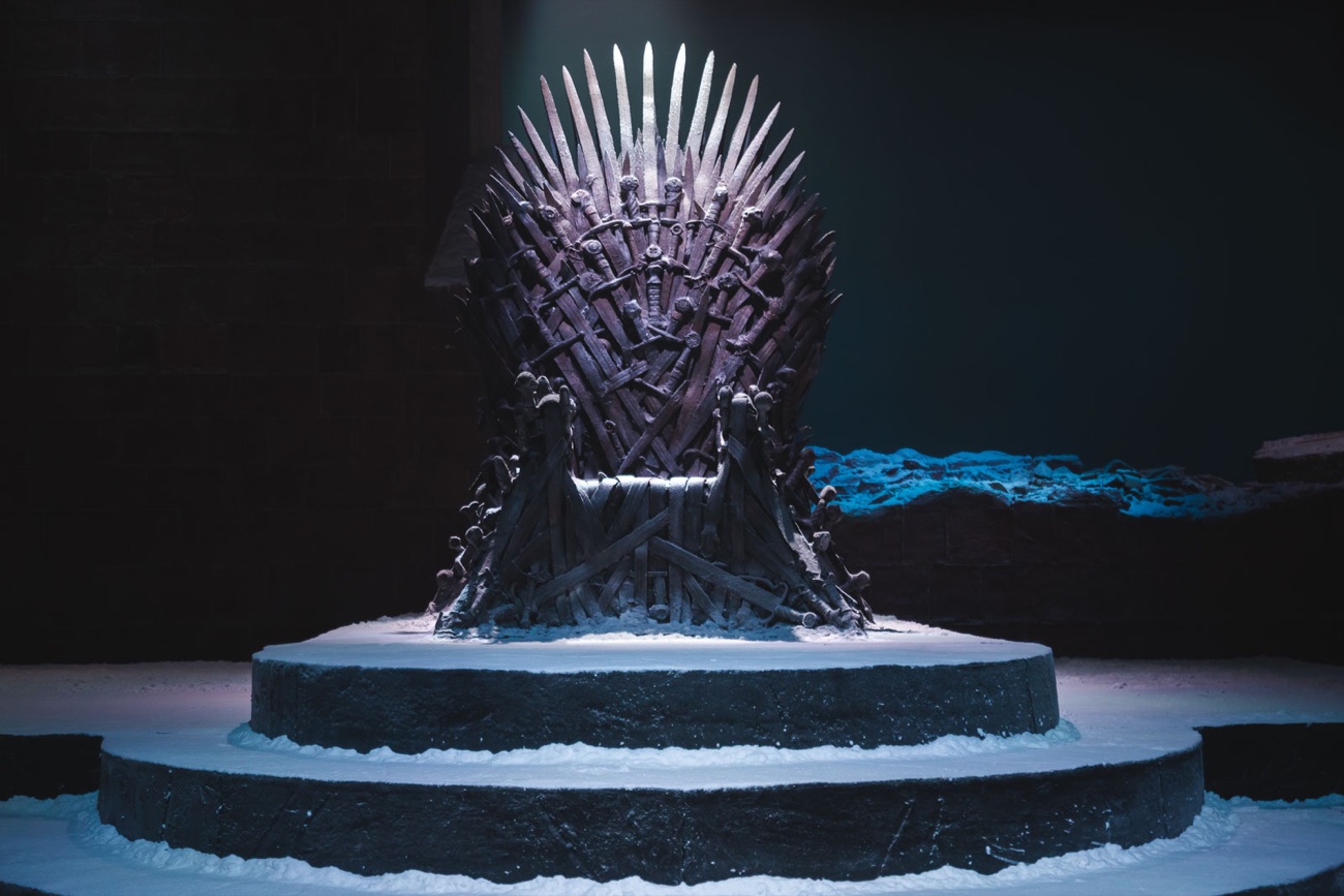 The Iron Throne on its snow-dusted dais under a single spotlight at the Game of Thrones Studio Tour