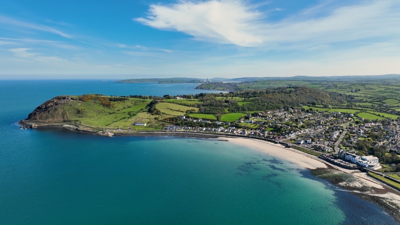 Ballygally Bay from above, with the headland and the rocky shore below the village