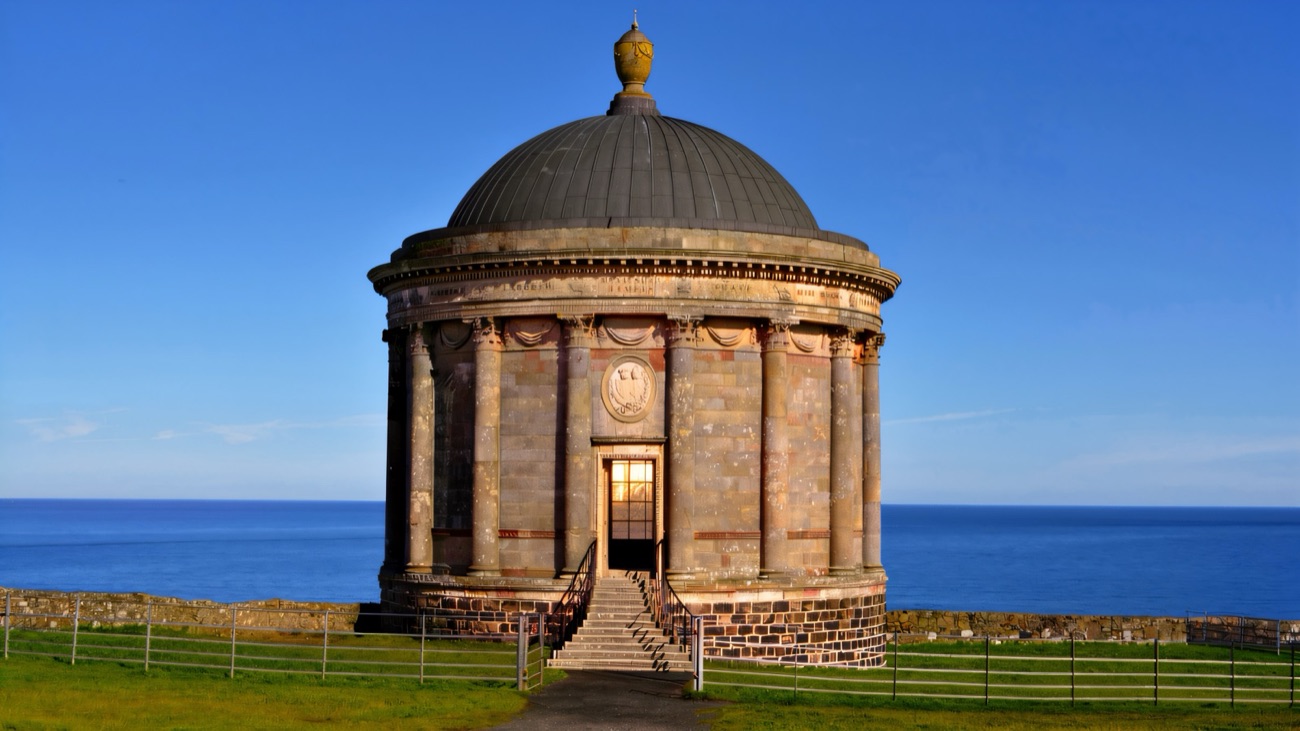 Mussenden Temple standing on the clifftop against a deep blue sea and sky