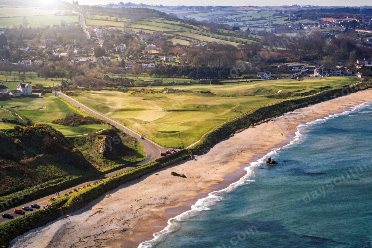 Aerial view of Ballycastle Beach curving past the golf links toward the town