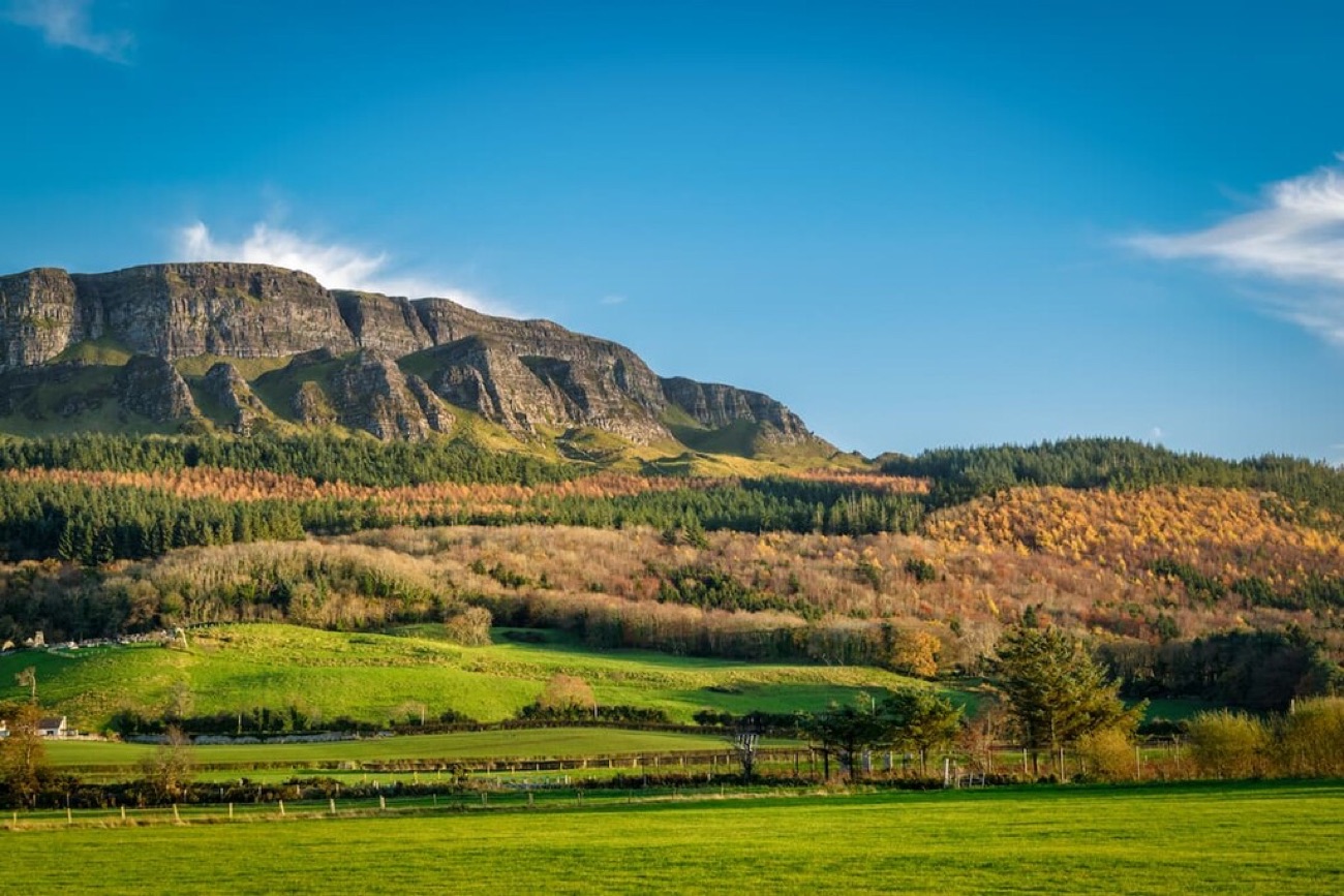 The long grey cliff line of Binevenagh mountain rising above patchwork fields near Limavady