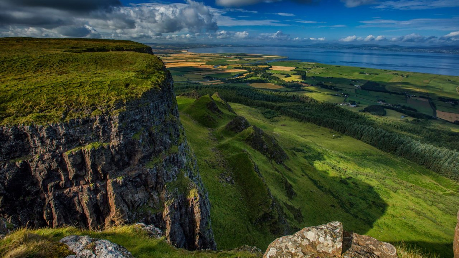 The basalt clifftop of Binevenagh dropping away to the green coastal plain and Lough Foyle far below