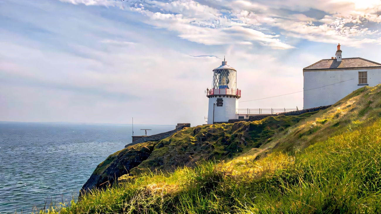 Blackhead Lighthouse close up on its grassy headland above the sea