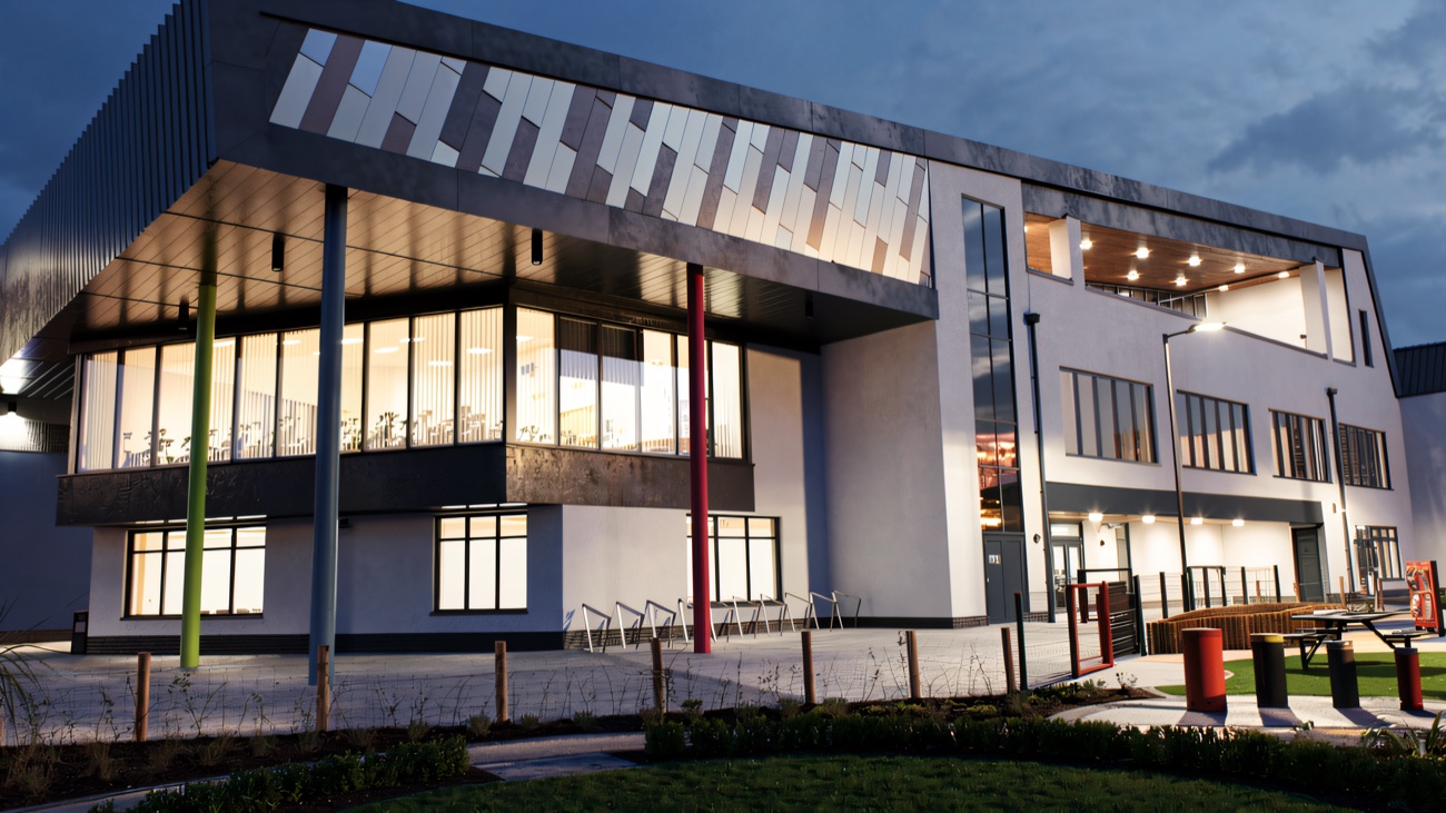 The leisure centre lit up against an evening sky