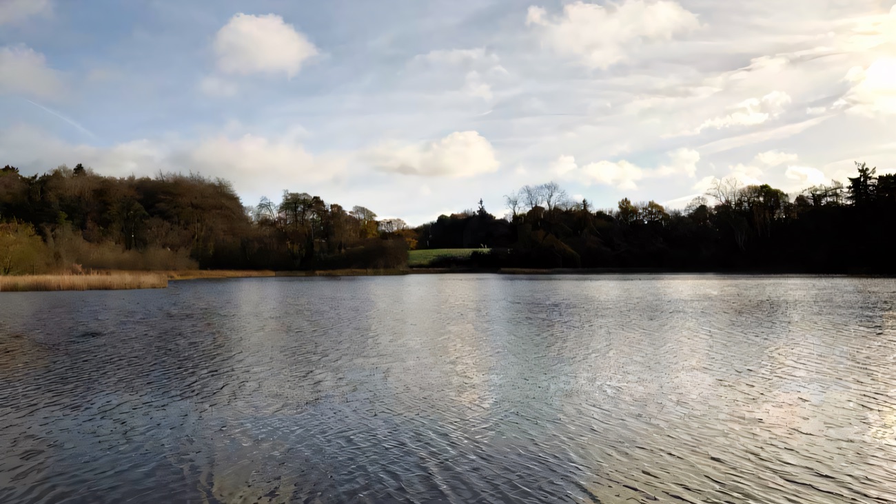 The open water of Lough Fadda, fringed with woodland and reeds