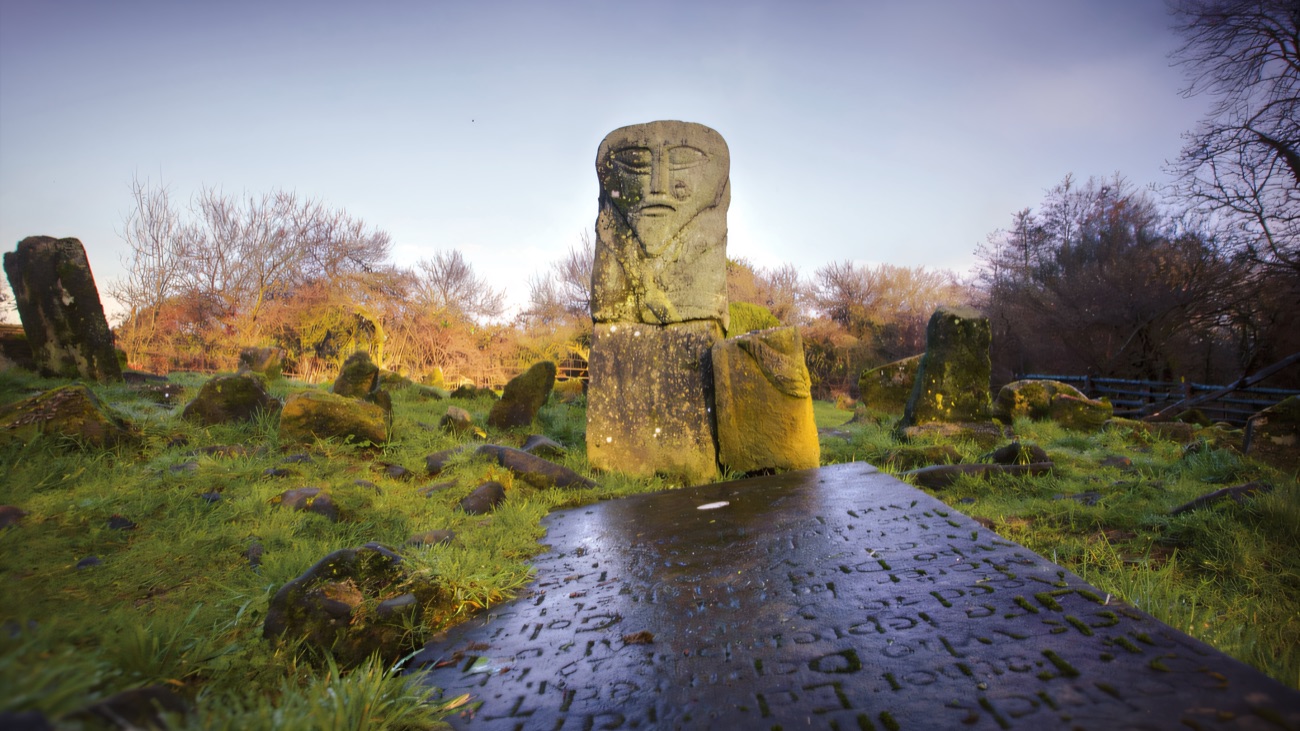 The ancient idol standing among mossy stones in the blue light of evening