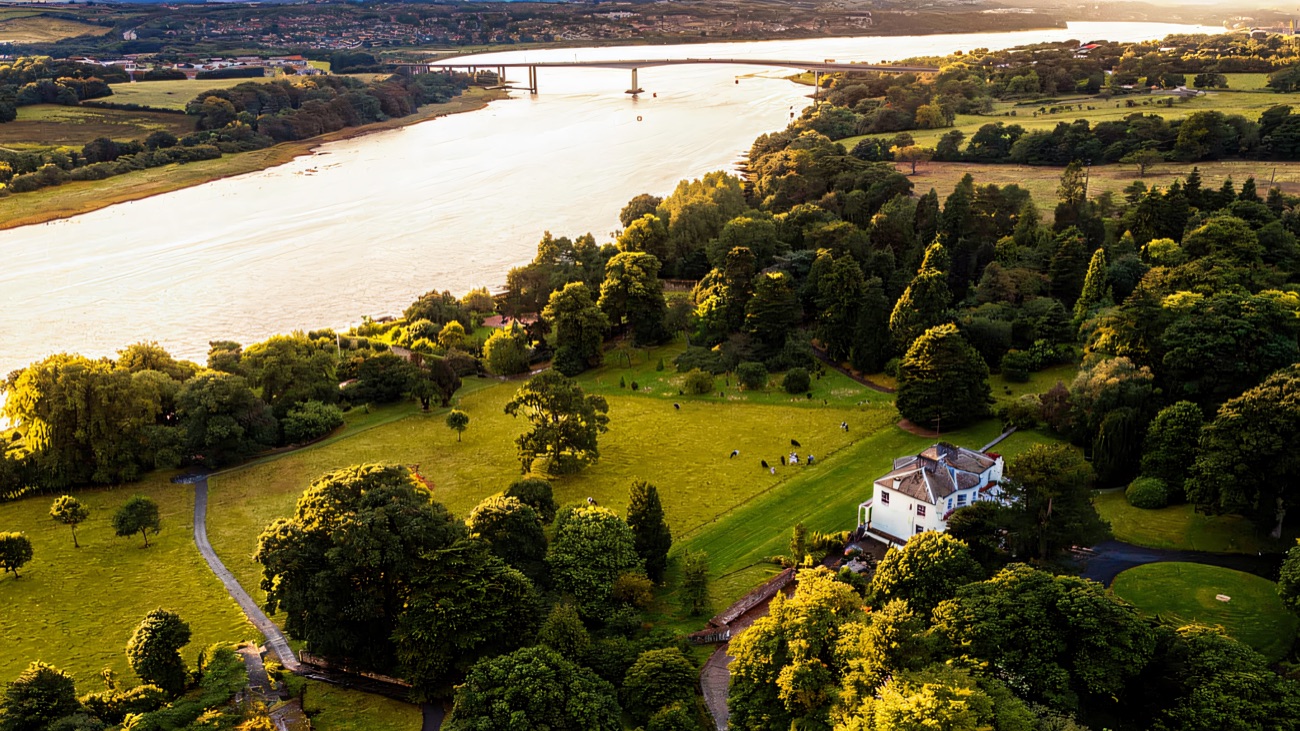 Aerial view of Brook Hall estate on the banks of the River Foyle with the Foyle Bridge beyond