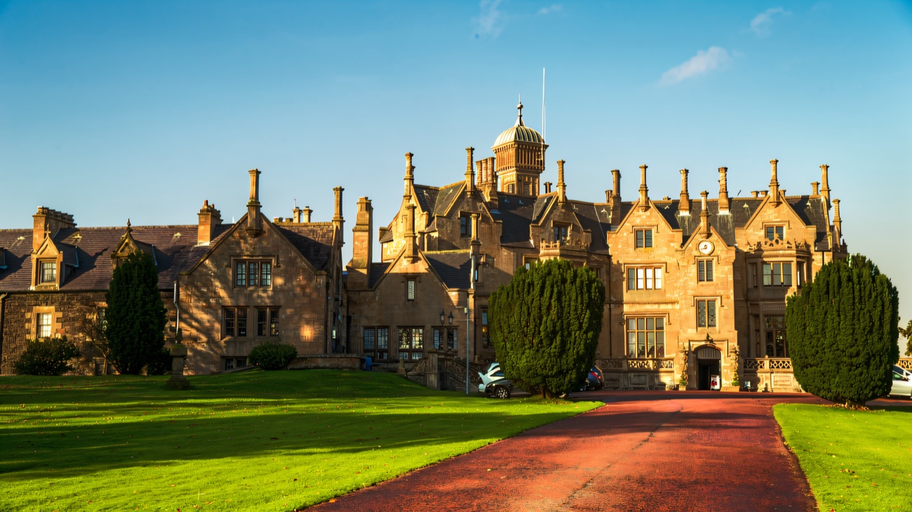 The long drive approach to Brownlow House showing the full sandstone mansion and its central lanterned tower
