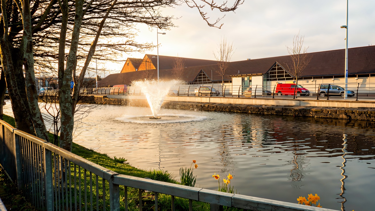 The fountain in the Newry Canal directly opposite Buttercrane Quay, with the shopping centre along the far bank