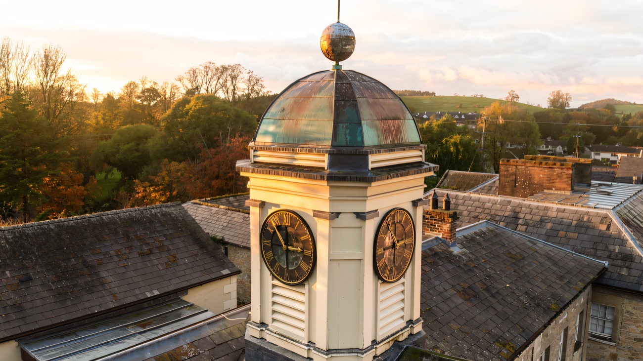 A closer look at the clock tower, its weathered copper dome and gilded faces catching the autumn light.
