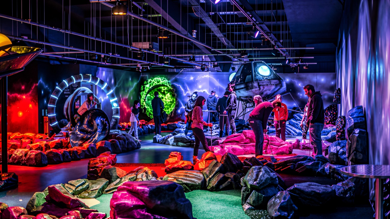 The wider space-themed course glows purple and blue with its lit portal and spaceship mural
