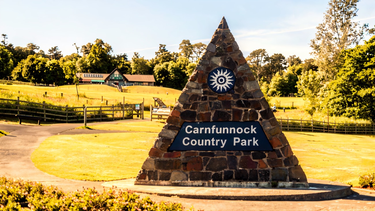 The stone pyramid entrance marker at Carnfunnock Country Park on the lawn, with the visitor buildings behind and trees around