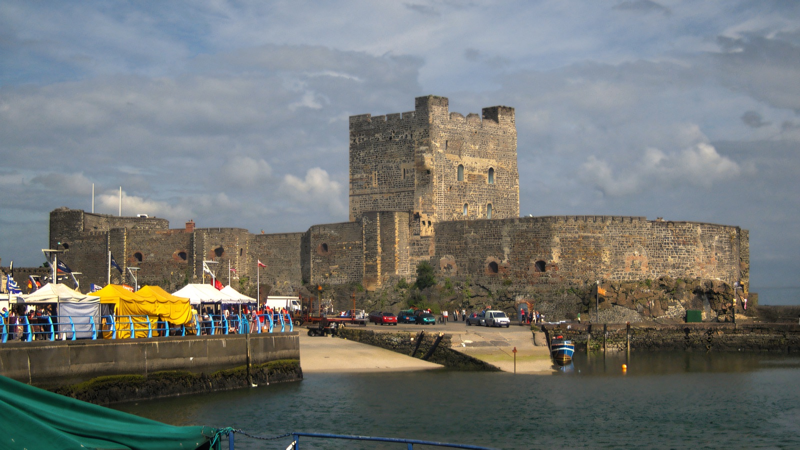 Carrickfergus Castle, the grey Norman keep and curtain walls, seen across the harbour on a bright day
