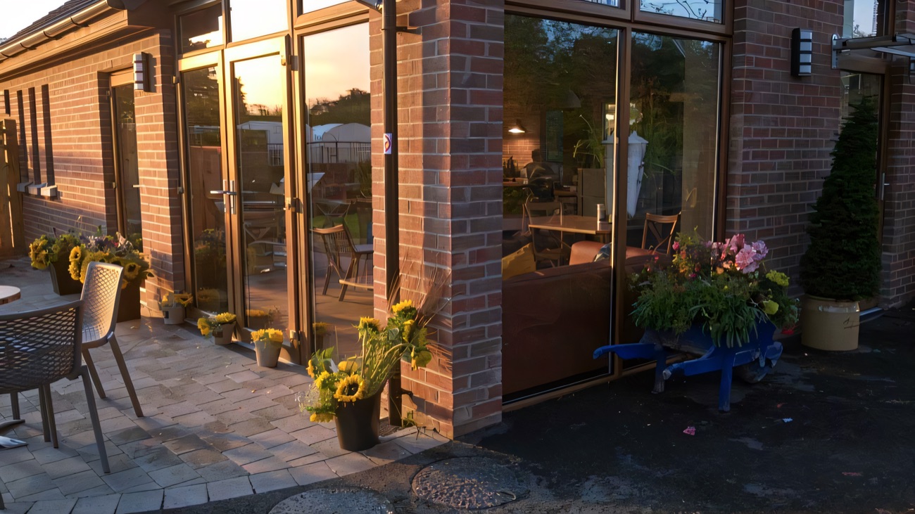 The Dancing Goat Café's outdoor seating and glass doors, with pots of sunflowers lined up along the front