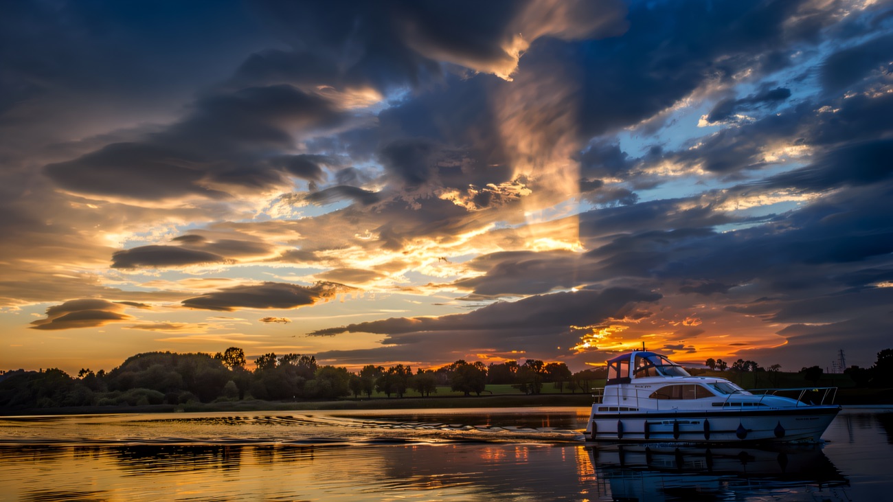 A cruiser gliding across the Erne beneath a dramatic evening sky.