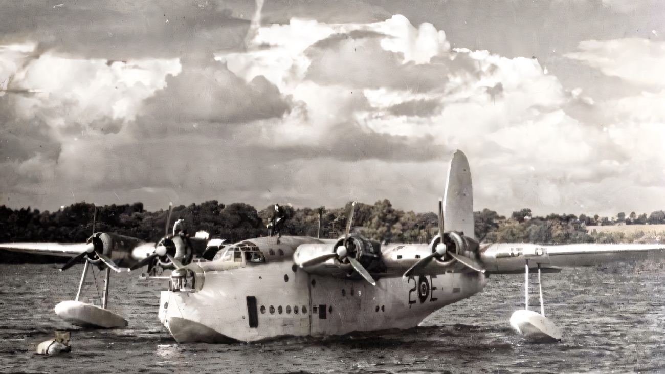 A historic black-and-white photograph of a wartime Short Sunderland flying boat sitting on the water