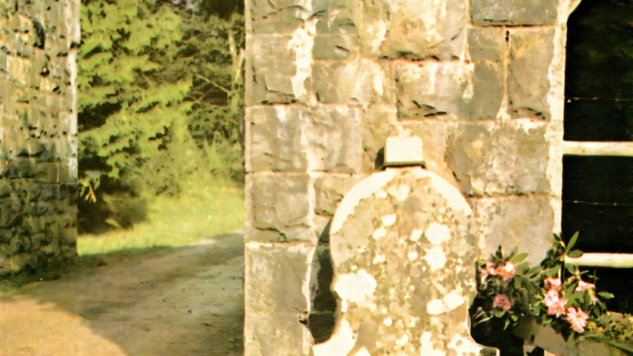 The Fiddlestone at Castle Caldwell — a fiddle-shaped stone set against the gateway with an inscribed plaque above it