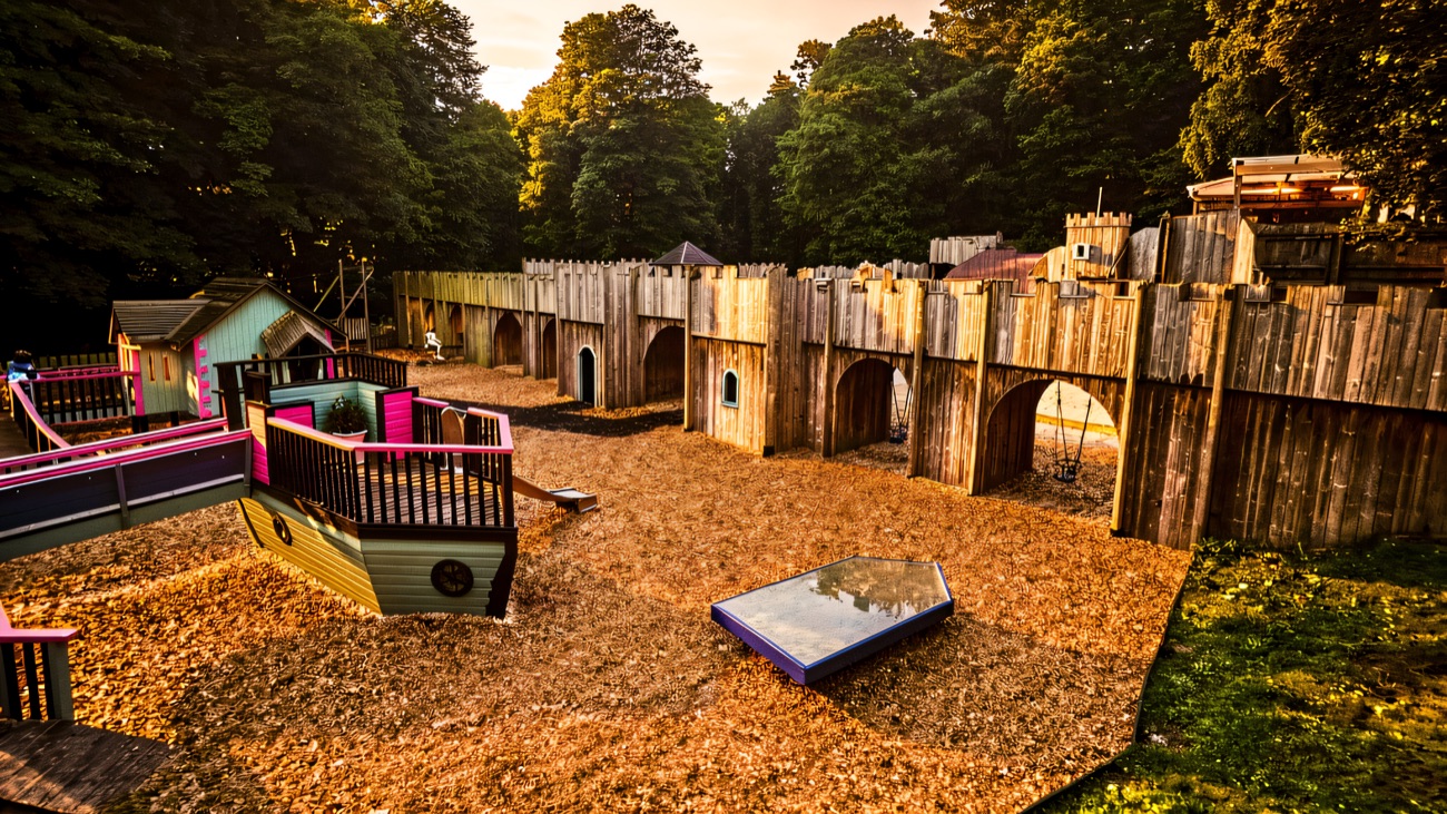 The large wooden fort-themed woodland adventure playground surrounded by trees