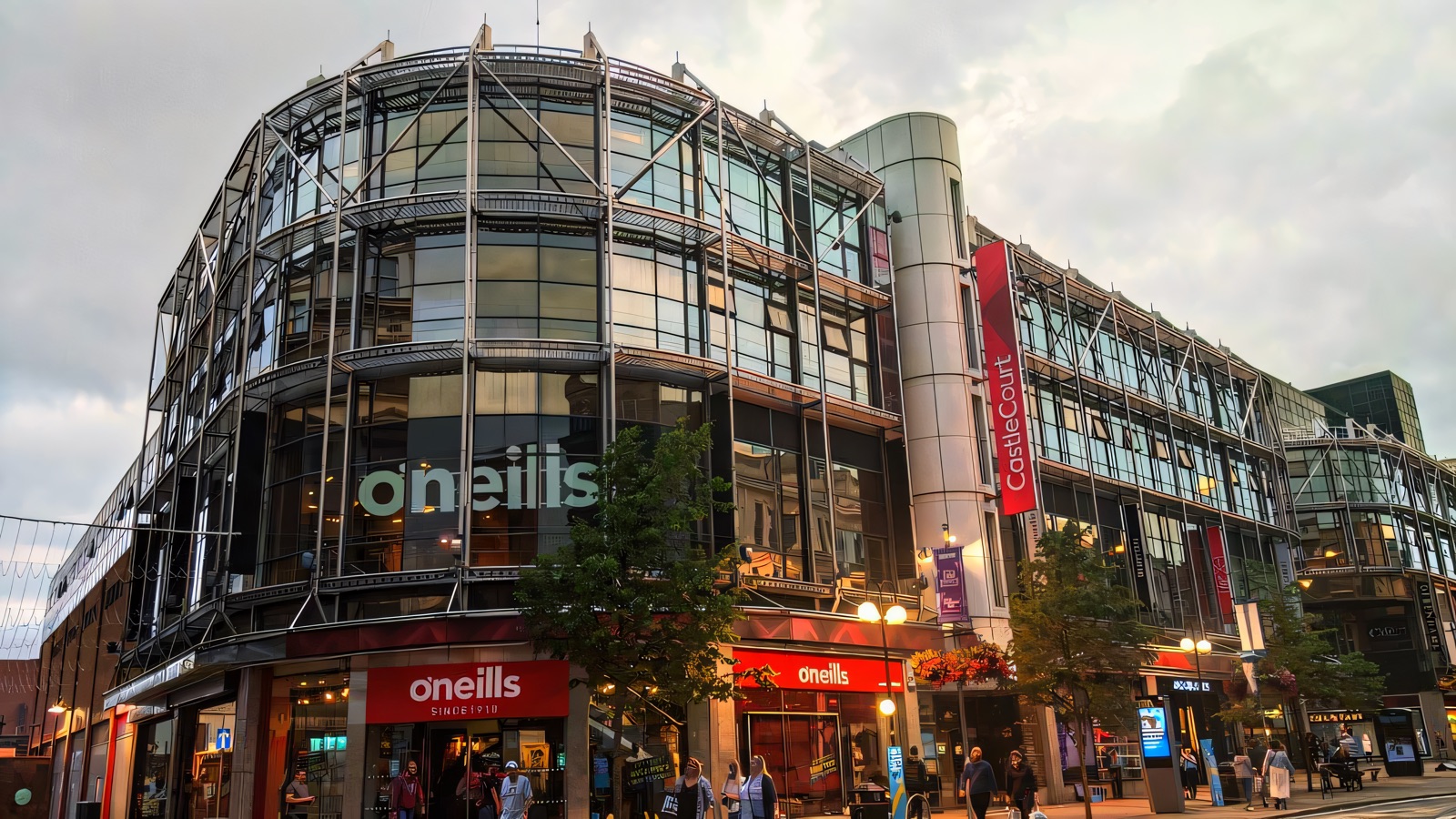 The glass front of CastleCourt Shopping Centre on Royal Avenue, Belfast, with the curved O'Neills corner and the CastleCourt banner on its steel frame